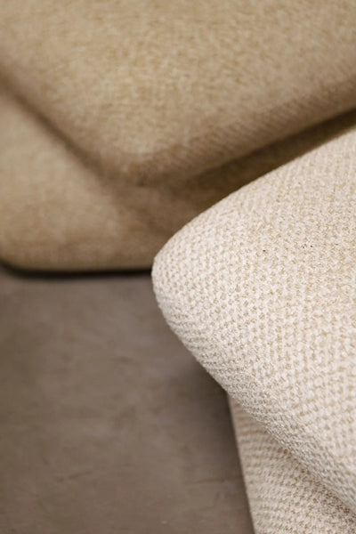 Taupe draaibare Aro Poef van PTMD met zachte bekleding en ronde vorm, geschikt als zithoek of decoratief meubel.