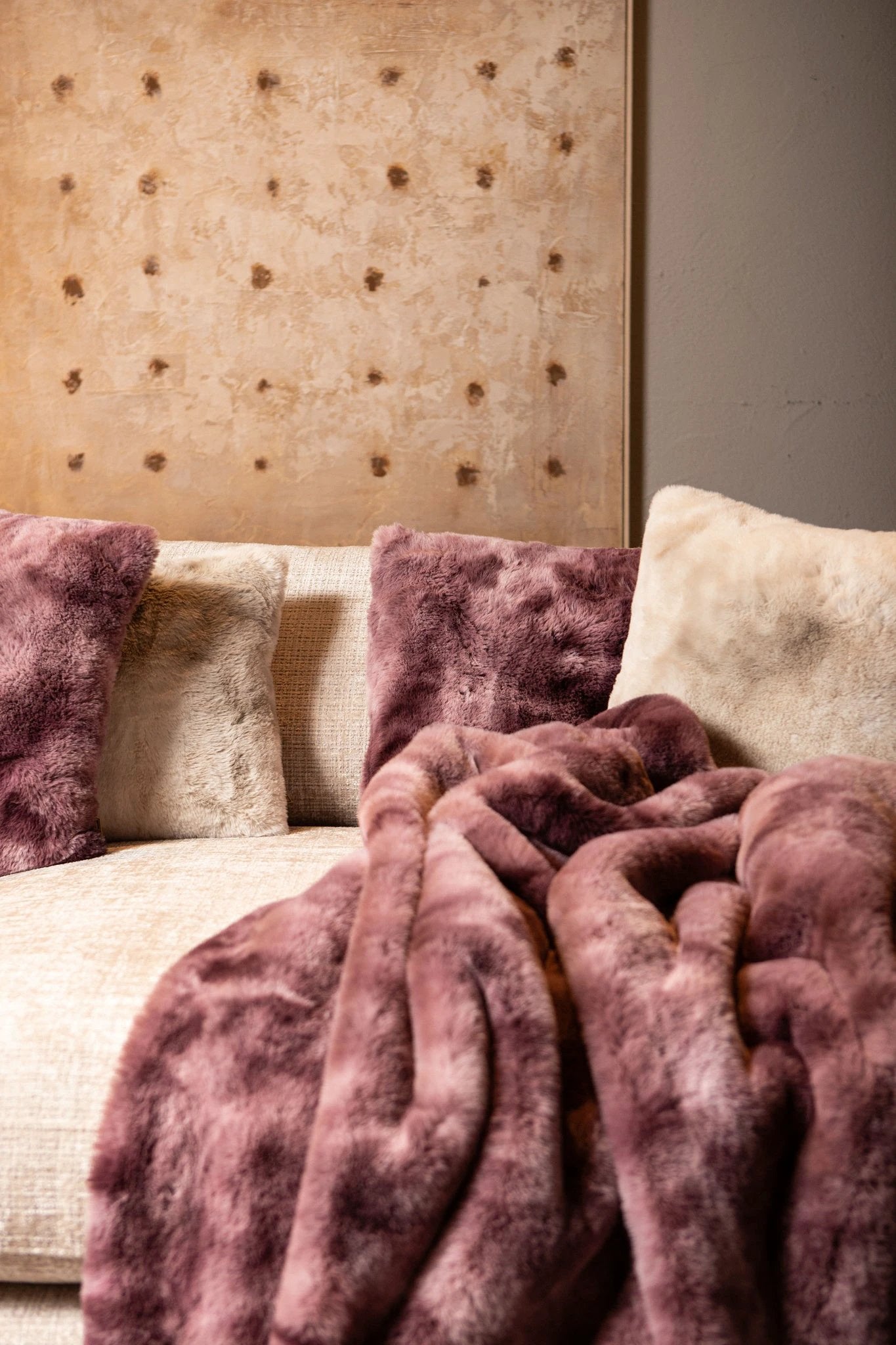 Linde Bordeaux faux fur vierkante kussen van PTMD met zachte, luxe stof en opvallende bordeaux kleur op een bank.
