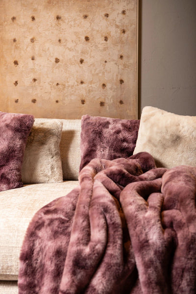 Linde Bordeaux faux fur vierkante kussen van PTMD met zachte, luxe stof en opvallende bordeaux kleur op een bank.