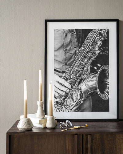 Moderne kunstprint "The Man with the Sax" van Urban Cotton, houten lijst, zwart-wit afbeelding van een man met saxofoon.